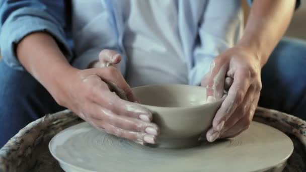 Femme enseigne à son fils à façonner un pot d'argile - Séquence, vidéo