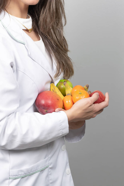 Ernährungsberaterin in ihrem Büro und zeigt gesundes Gemüse und Obst. Gesundheits- und Ernährungskonzept. Lebensstil. - Foto, Bild