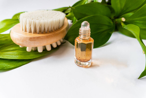 Szczotka do masażu z naturalnymi szczecinami do obierania ciała lub masażu antycellulitowego, z olejkiem eukaliptusowym. - Zdjęcie, obraz