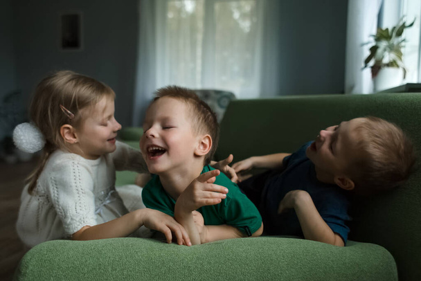 Three beautiful kids and have fun lying on the couch at home. - Fotografie, Obrázek