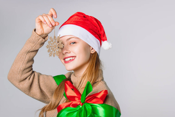 Lady with a gorgeous smile holding a Christmas tree star on a white background. High quality photo - Fotó, kép