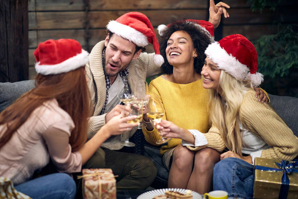 Group of happy young people celebrating Christmas or New Year together; House party concept - Photo, image