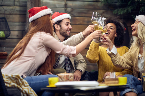 Group of happy young people celebrating Christmas or New Year together; House party concept - Foto, Bild