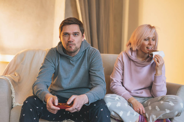 Fiatal család otthoni ruhák videojátékok a kanapén a nappaliban - Fotó, kép