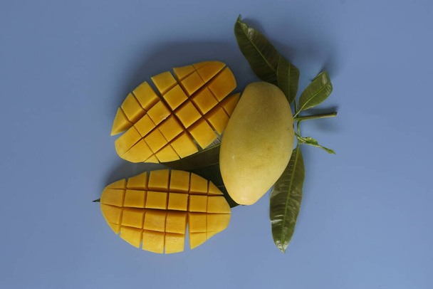 рубленые фрукты манго на синем фоне - Фото, изображение