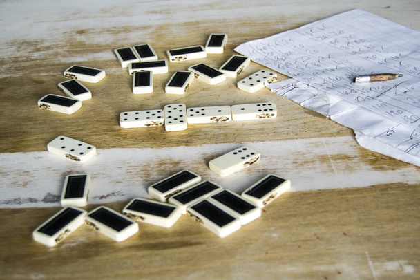 alte Dominosteine liegen auf einem schäbigen Tisch - Foto, Bild