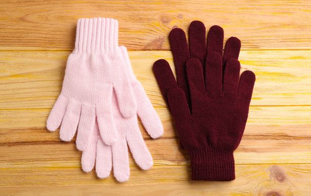 Stylish gloves on wooden background, flat lay - Foto, imagen