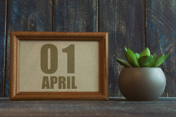 1 апреля. 1 апреля. День 1 месяца, дата в рамке рядом с сочным на деревянном фоне весенний месяц, день года концепции. - Фото, изображение