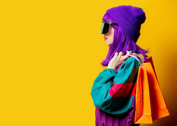 Στυλ γυναίκα σε γυαλιά VR και 80 tracksuit με σακούλες κοπής σε κίτρινο φόντο - Φωτογραφία, εικόνα