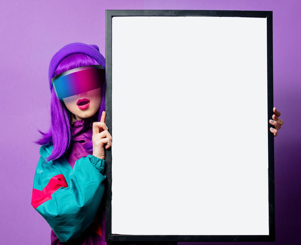 Stijl vrouw in VR bril en 80s trainingspak en mockup frame op violette achtergrond - Foto, afbeelding