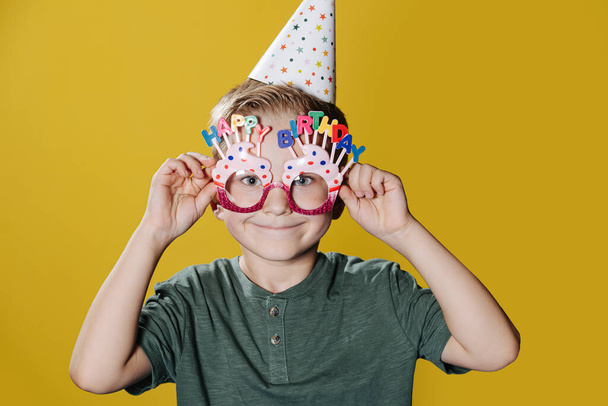 Cute smiling ten year old birthday boy standing in front of the wall - Foto, Imagen