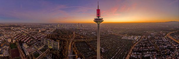 Immagine drone panoramica dello skyline di Francoforte con torre televisiva la sera durante un tramonto colorato e impressionante in inverno - Foto, immagini