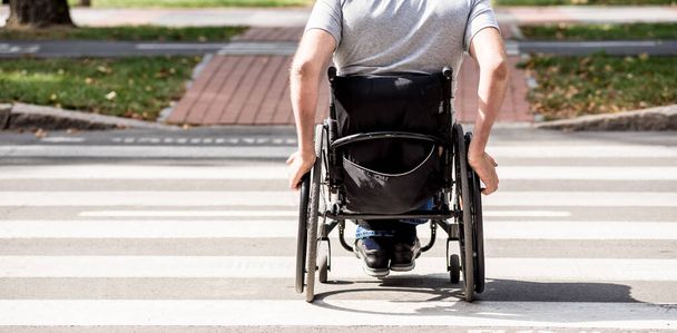 Handicapped man in wheelchair crossing street road - Fotoğraf, Görsel