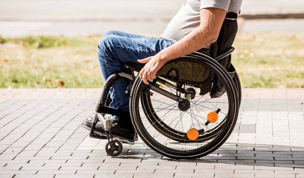 Hombre discapacitado en silla de ruedas caminar en el callejón del parque - Foto, Imagen