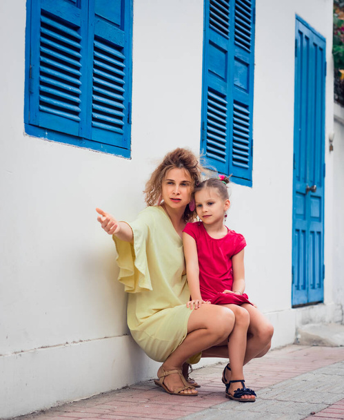 Mother and daughter next to shutter window in a street - Fotografie, Obrázek
