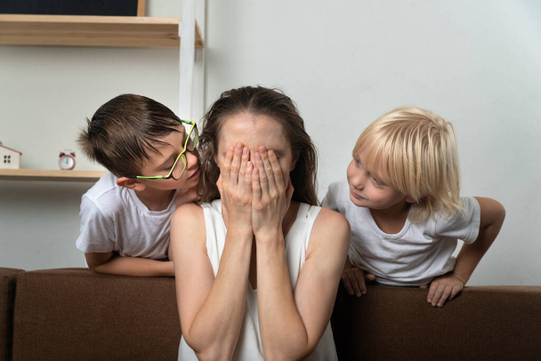 Los hijos consuelan a su madre molesta. Los niños sienten lástima por su madre llorando - Foto, imagen