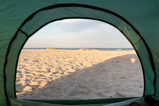 Vista dall'interno della tenda in mare e spiaggia sabbiosa. Campeggio sul mare. - Foto, immagini
