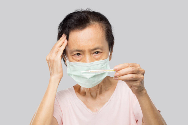 vieille asiatique femme vérifier thermomètre après son sentir fièvre et malade - Photo, image