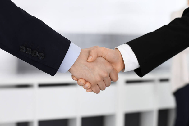 Businessman and woman shaking hands in office. Concept of handshake as success symbol in business - Φωτογραφία, εικόνα