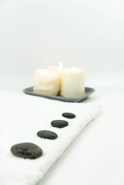 Gris zen guijarros piedras calientes con toalla en la mesa de masaje en el salón de belleza. Ajuste de masaje de piedra caliente. Concepto conjunto de armonía, equilibrio y meditación, spa, relax, tratamiento de spa - Foto, Imagen