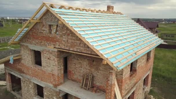 Luftaufnahme eines im Bau befindlichen Backsteinhauses mit Holzdachstuhl. - Filmmaterial, Video