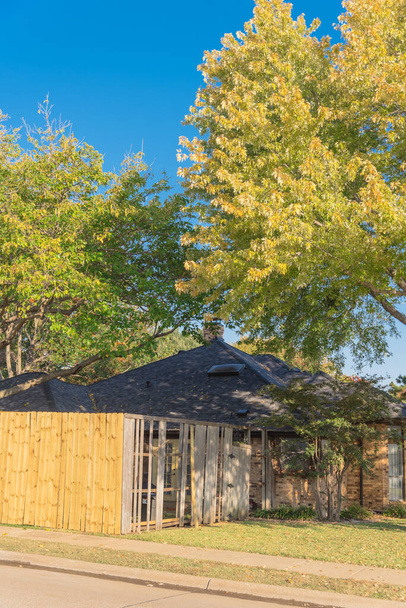 Die Erneuerung des Holzzaunes an einem Eckhaus in der Nähe von Dallas, Texas, ist im Gange. Blick in den Vorgarten der neuen Privatsphäre Wand Installation in der Nähe eingestürzt verwitterte Bretter Latten Holzbalken - Foto, Bild