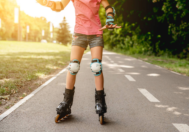 Roller skates on girl in park - Фото, изображение