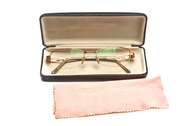 Óculos em armações de metal dourado em um caso em um fundo leve - Foto, Imagem
