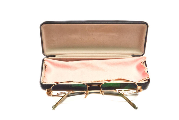 Óculos em armações de metal dourado em um caso em um fundo leve - Foto, Imagem