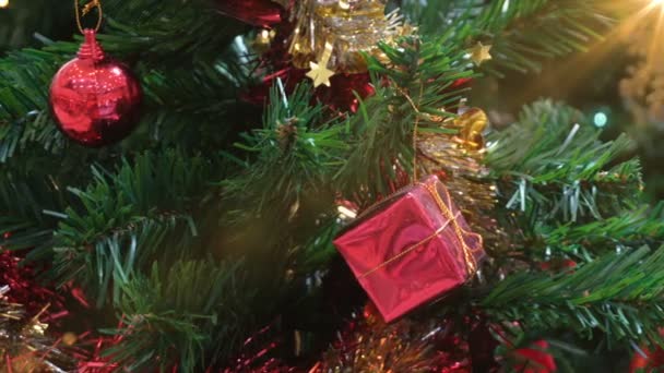 Подарочные коробки и шары украшены светом на елке во время праздничного сезона. - Кадры, видео