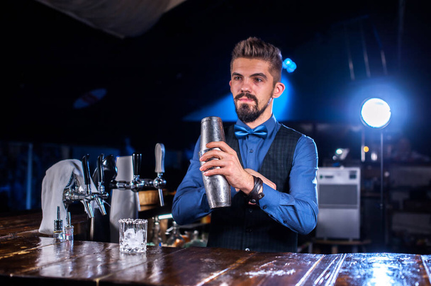 Barista barbuto mette i tocchi finali su un drink al nightclub - Foto, immagini