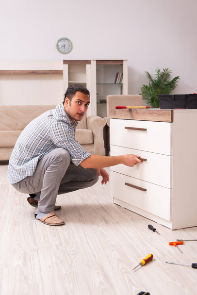 Young male carpenter repairing furniture at home - Photo, Image