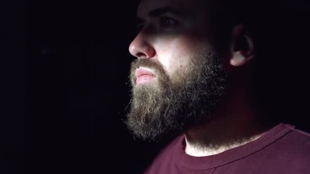 Close-up gezicht van een man met een baard in het donker - Video