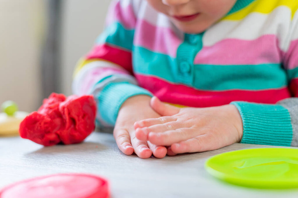 Cute girl having fun playing with colorful dough at home. - Foto, Bild