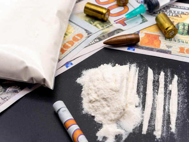 шприц стодолларовые купюры героин кокаина и пистолетные картриджи наркозависимость концепция социальных проблем - Фото, изображение