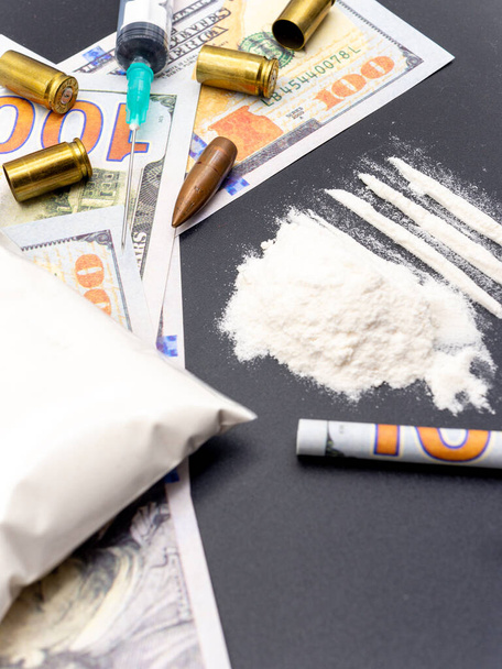 spuit honderd dollar biljetten cocaïne heroïne en pistoolpatronen drugsverslaving sociale kwesties concept - Foto, afbeelding