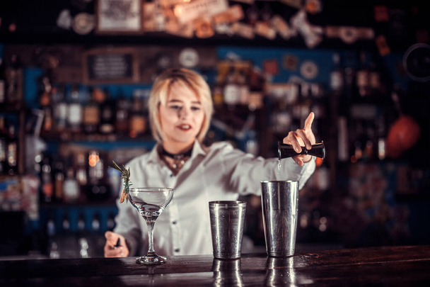 Girl bartender makes a cocktail behind the bar - Photo, Image