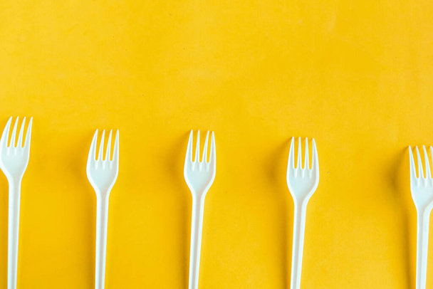 Plastic forks on yellow background, top view - Photo, Image