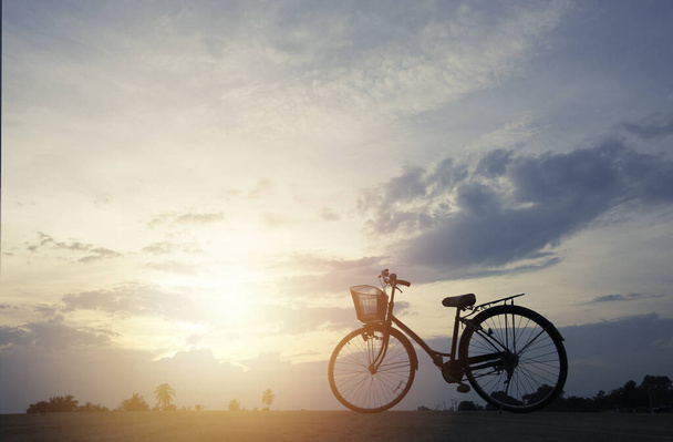 σιλουέτα ποδηλάτου με όμορφο cloudscape και το ηλιακό φως. - Φωτογραφία, εικόνα