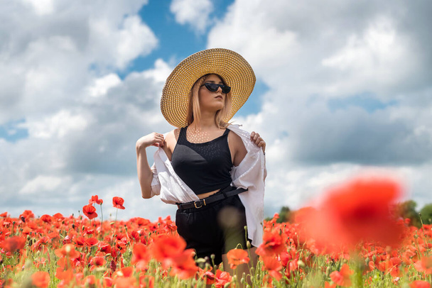 Yazın haşhaş tarlasında hasır şapkalı güzel bir genç kadın. güzellik doğası - Fotoğraf, Görsel