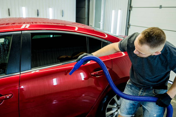 Service medewerker maakt automatisch drogen van de auto na het wassen. - Foto, afbeelding