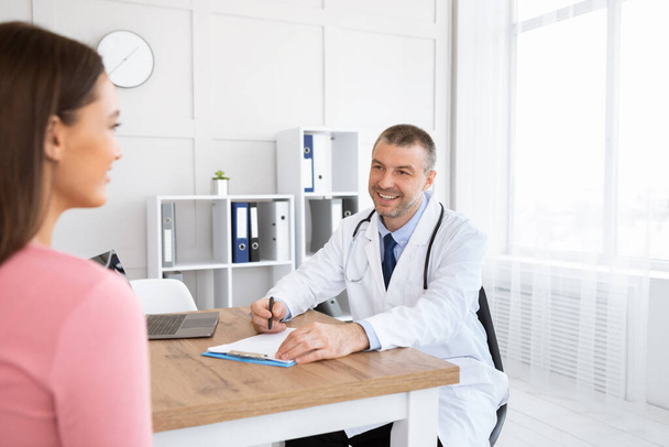 Sonriente médico experimentado hablando con su paciente - Foto, Imagen
