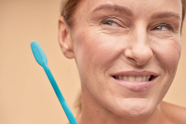 Hymyilevä kypsä nainen aikoo harjata hampaansa - Valokuva, kuva