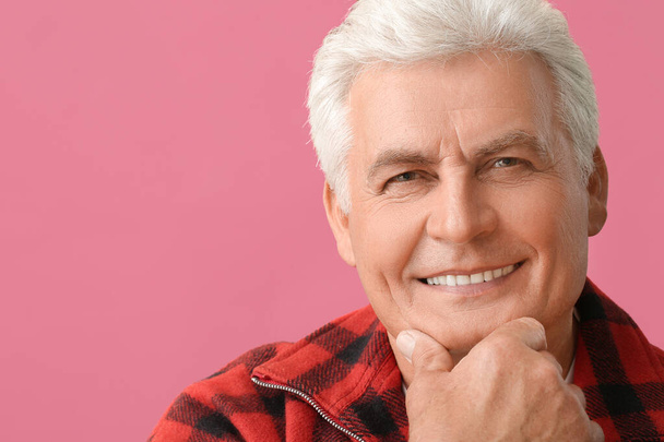 Stylish senior man on color background - Foto, afbeelding