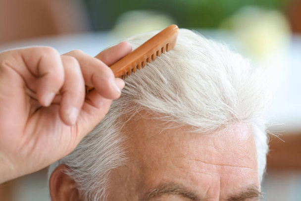 Älterer Mann kämmt sich zu Hause die Haare, Nahaufnahme - Foto, Bild