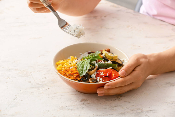 Woman eating rice salad with vegetables - 写真・画像