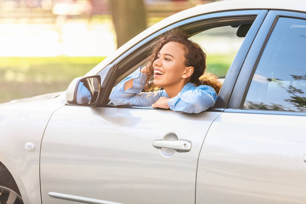 Szczęśliwa Afroamerykanka wyglądająca przez okno samochodu - Zdjęcie, obraz