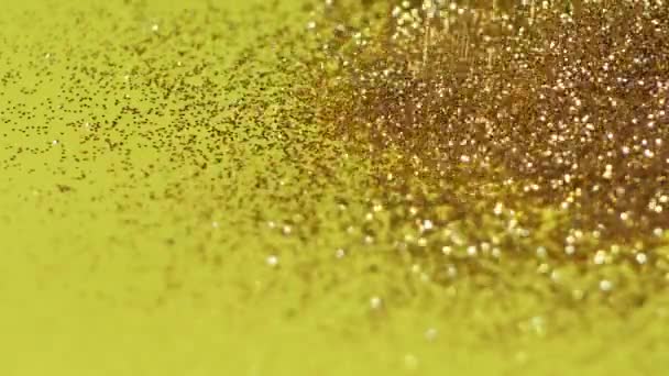 Gouden Glitter fonkelend Magisch licht. Glanzend goud Stof deeltjes Trail Oversteken schitteren op een gele achtergrond - Video