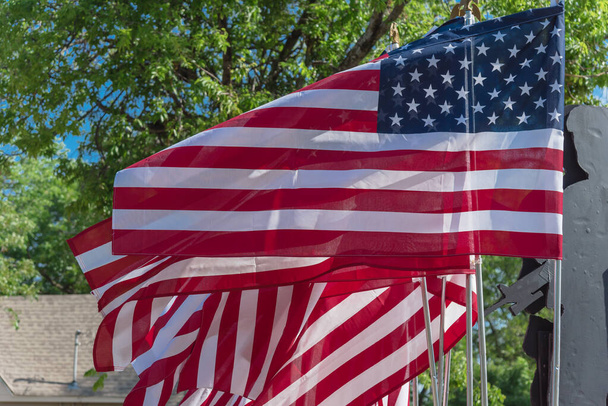 Κοιτάζοντας ψηλά κυματίζοντας αμερικανικές σημαίες με πράσινα δέντρα φόντο σε μια ειρηνική διαμαρτυρία κοντά στο Ντάλας, Τέξας, Αμερική. Περήφανος πορεία, συγκέντρωση, πατριώτης, διαμαρτυρία έννοια - Φωτογραφία, εικόνα