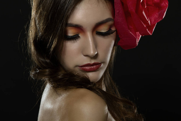 Vintage portrait of fashion glamour girl with red flower in her hair, over black. Studio shot. Spanish Carmen style - Fotografie, Obrázek